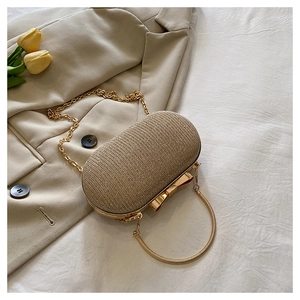 Detail of champagne gold sequined evening clutch bag with bow clasp and chain strap