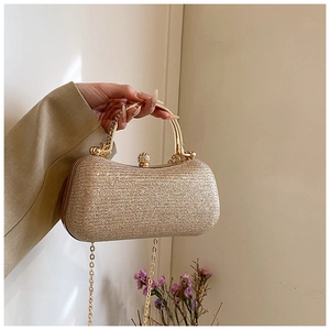Detail of champagne gold evening bag with metallic sequin texture and golden chain handle