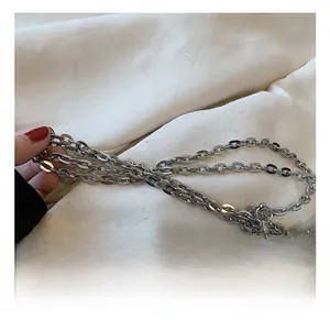 Close-up of premium polished silver metal chain link strap on textured fabric