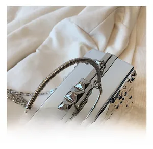 Detail of silver evening bag with sparkling rhinestones and a textured metal handle