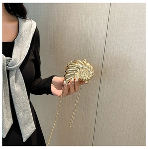 Detaillierte Nahaufnahme der goldenen Metall-Abendtasche in Schneckenform mit Kette