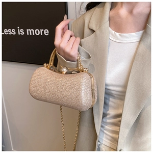 Detail of champagne gold glitter clutch featuring a diamond-encrusted lock and metal handle