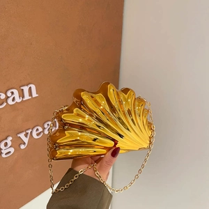 Chic gold shell-shaped evening clutch bag with metallic mirror finish and chain strap