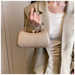Detailed view of shimmering gold sequin evening bag with elegant rhinestone ball clasp