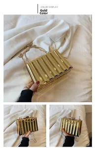 Detailed view of golden wave-textured acrylic box clutch with metallic handle and chain