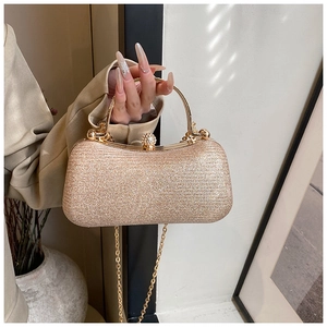 Detail of glitter champagne gold evening clutch with metal handle and diamond clasp