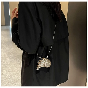 Detailansicht der silbernen Abendtasche in Schneckenform mit Metallic-Textur und Kette