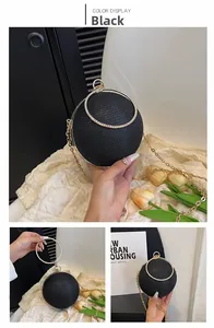 Détail du sac de soirée sphérique noir avec poignée en strass et bandoulière dorée