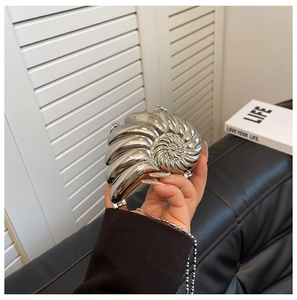 Detailansicht der silbernen Abendtasche in Muschelform mit metallischem Glanz