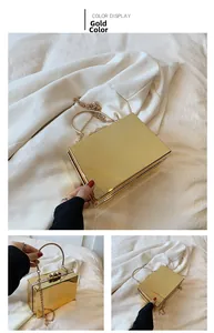 Detail of gold metallic clutch bag with top handle, rivet clasp and delicate chain strap