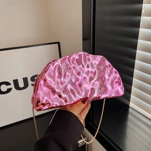 Pink metallic irregular acrylic clutch bag with gold chain strap in hand display