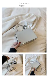 Macro view of silver mirror acrylic clutch bag with metal handle and chain strap