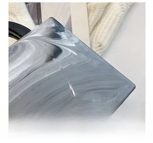 Detail showing marble texture acrylic small square bag with black round handle