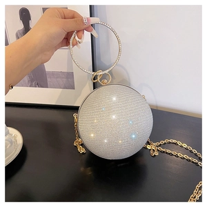 Détail du sac de soirée sphérique à paillettes avec poignée en strass et chaîne dorée
