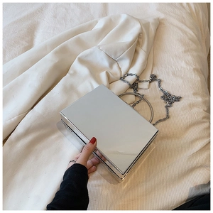 Detail of silver mirror acrylic box bag with rhinestone handle and metal chain strap
