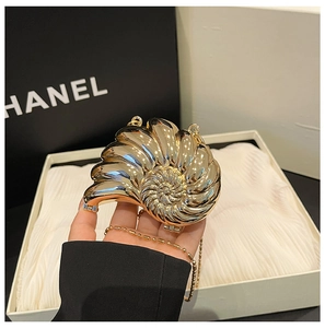 Detail einer luxuriösen schneckenförmigen goldenen Abendtasche mit polierter Metalloberfläche