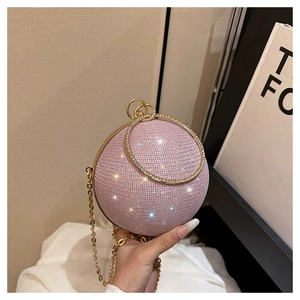Détail de la pochette boule rose avec strass, poignée ronde dorée et bandoulière