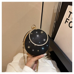 Détail du sac de soirée sphérique noir pailleté avec poignée dorée et strass brillants