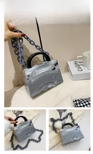 Detail of gray marble pattern acrylic box bag with chunky plastic chain and gold clasp