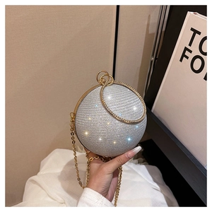 Détail du sac de soirée sphérique argenté orné de cristaux avec poignée anneau dorée