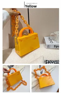 Detail of yellow marble acrylic handbag with thick plastic chain and top handle strap