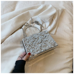 Detailed shot of silver lava texture on acrylic evening clutch bag with metal handle