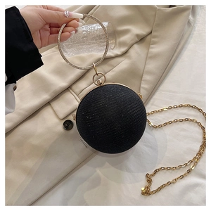 Détail d'un sac de soirée sphérique noir avec finition pailletée et anse en strass