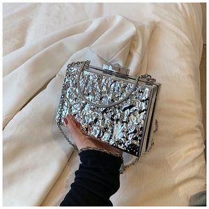 Detail of silver acrylic clutch bag with hammered texture and diamond-cut clasp