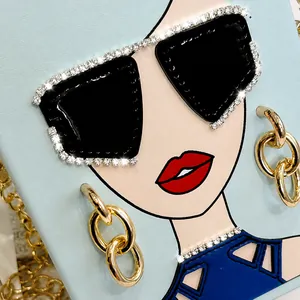 Detail der hellblauen Ledertasche mit moderner Mädchen-Illustration und Strass-Sonnenbrille