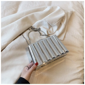 Macro view of silver wave texture and metal handle on acrylic box clutch bag