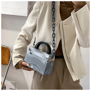 Detail view of marble pattern square bag with acrylic chain and gold metal hardware