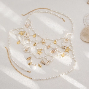 Close-up of pearl body chain with gold starfish and natural seashell charms for beachwear