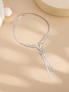 Detail of silver snake chain necklace showing a knotted design and fluid metallic tassels