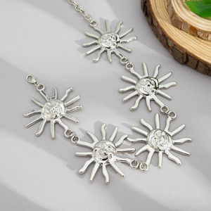 Detailed macro view of silver sun charms with facial relief on a stylish body chain