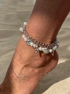 Close-up of bohemian double-layer anklet with starfish, seashell charms and white pearls