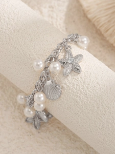 Detail of silver starfish and shell charms with imitation pearls on a beach anklet