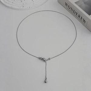 Detail van zilveren slangenketting met elegante gepolijste metalen kralen hanger
