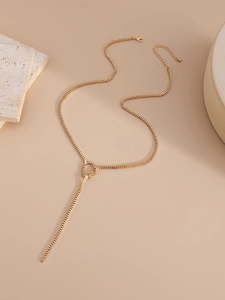 Detail of adjustable gold box chain Y-necklace with lobster clasp on textured stone