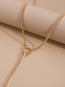 Detail of gold box chain necklace with adjustable sliding ring and Y-shaped tassel drop