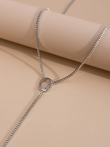 Close-up of a silver box chain necklace with a stylish y-shaped knot link detail