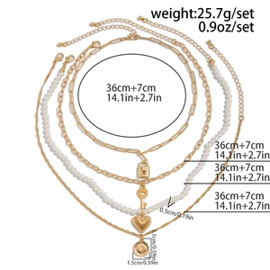 Detail of layered gold necklaces with padlock, key, pearls, and coin pendants set