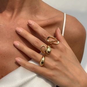 Ensemble de trois bagues dorées minimalistes aux formes irrégulières portées par mannequin