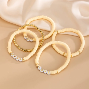 Set di 5 braccialetti bohémien in argilla crema con perline a lettere MAMA e LOVE dorate