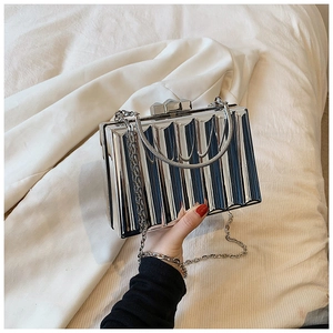 Detailed close-up of a silver metallic pleated clutch bag with elegant chain strap