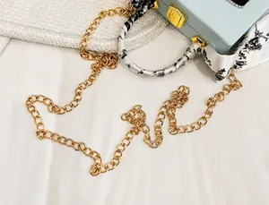 Detail der hellblauen Box-Tasche mit goldenem Verschluss und Seidenschal-Griff