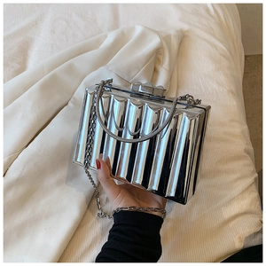 Close-up of silver metal evening bag featuring vertical accordion pleats and chain strap