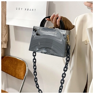 Detail view of the black and grey marble textured acrylic crossbody box bag with chain