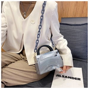Detail of marble pattern acrylic handbag with blue chain strap and resin handle