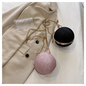 Détail des sacs de soirée sphériques à paillettes noires et roses avec poignées dorées