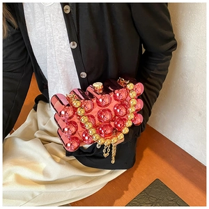 Detailed view of bubble texture on rose pink metallic acrylic clutch with gold bead handle